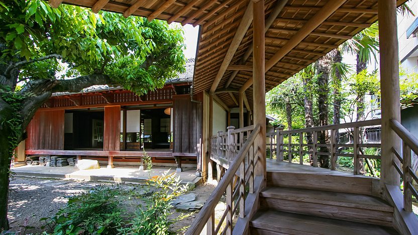 A photo of a walkway in the Kamihaga Residence. The opening to a traditional Japanese house can be seen in the background.